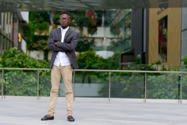 Porträt des jungen afrikanischen Geschäftsmannes in der Stadt im Freien