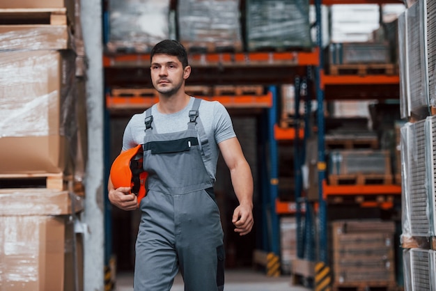 Porträt des jungen Arbeiters in uniprom, der im Lager ist.