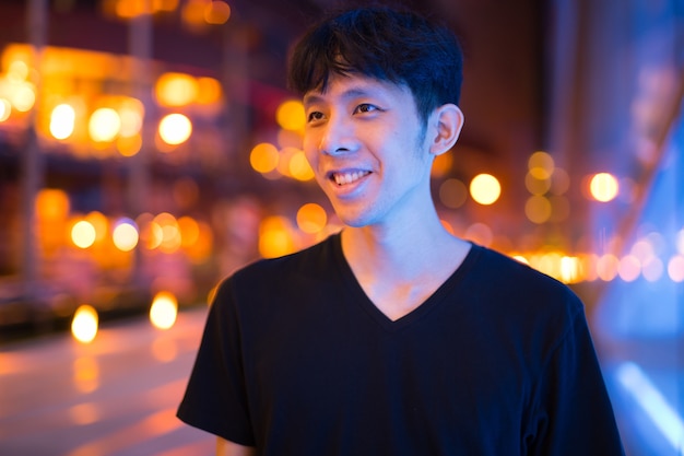 Porträt des jungen asiatischen Mannes draußen bei Nacht