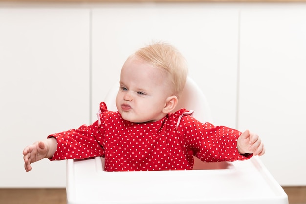 Porträt des jungen Babymädchens im Hochstuhl