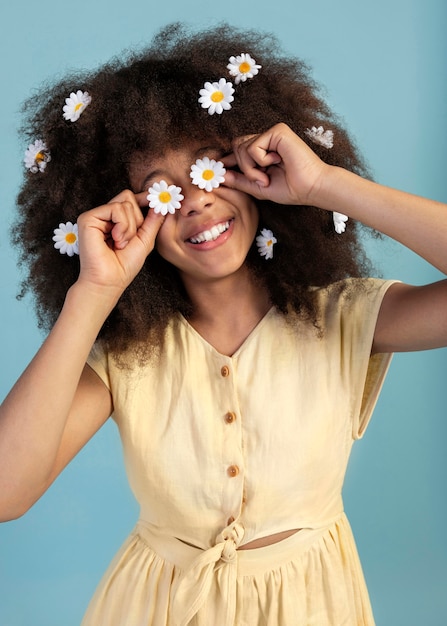 Foto porträt des jungen entzückenden mädchens, das mit kamillenblumen aufwirft