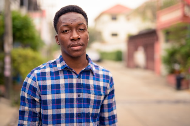 Porträt des jungen gutaussehenden afrikanischen Mannes in den Straßen draußen