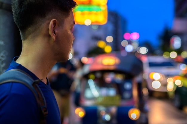 Porträt des jungen hübschen asiatischen Touristenmanns, der Chinatown in Bangkok, Thailand erforscht