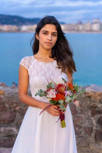 Porträt des jungen kaukasischen Mädchens in einem weißen Hochzeitskleid