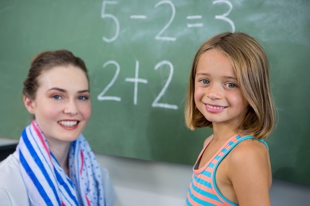 Foto porträt des jungen lehrers mit mädchen im klassenzimmer