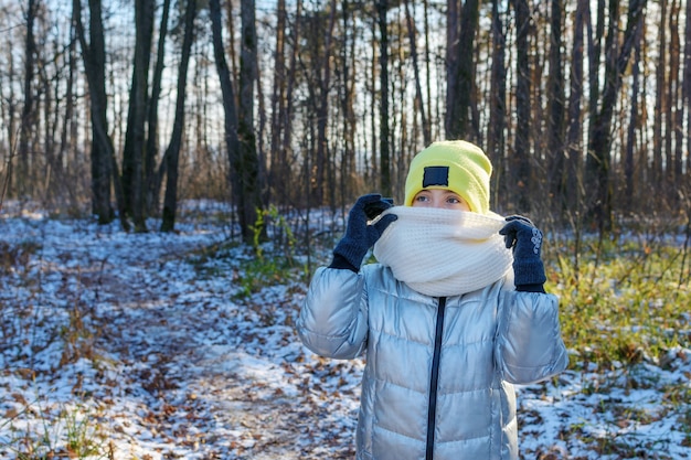 Foto porträt des jungen mädchens, das schal anstelle der schutzmaske trägt, die im winterpark geht