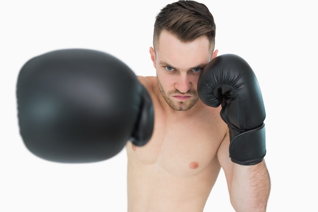 Porträt des jungen männlichen Boxers, der über weißem Hintergrund locht