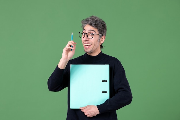 Porträt des jungen Mannes, der Dokumente hält Studioaufnahme auf grünem Hintergrund Geschäftslehrer-Unterrichtsjob