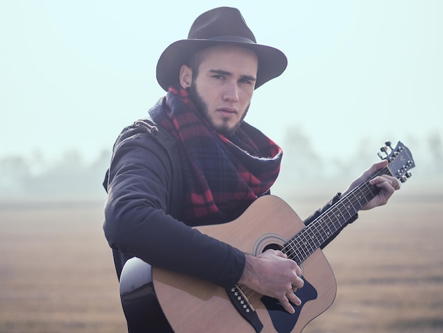 Porträt des jungen Mannes Gitarre spielend