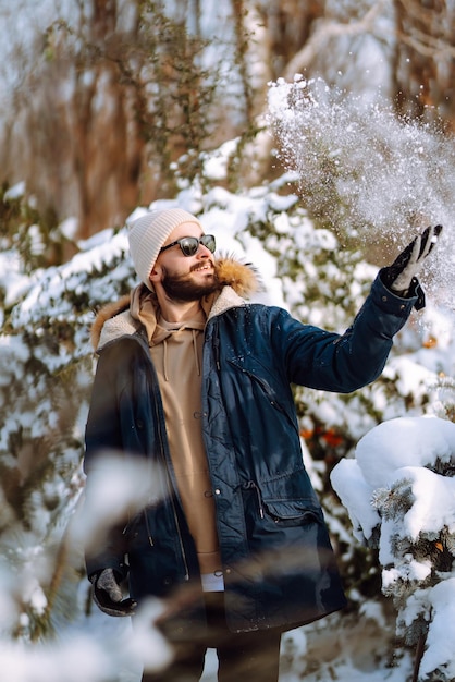 Porträt des jungen Mannes im verschneiten Winterwald Jahreszeit, Weihnachten, Reise- und Personenkonzept