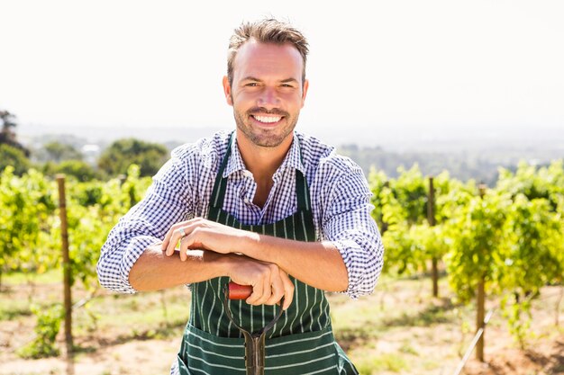 Porträt des jungen Mannes mit Schaufel am Weinberg