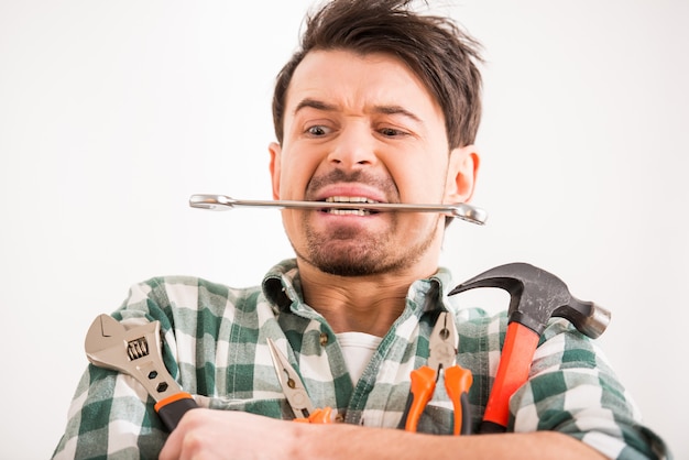 Porträt des jungen Mannes tut Reparatur zu Hause mit Werkzeugen.