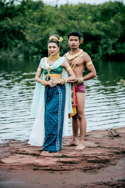 Porträt des jungen Mannes und der Frau, die schöne traditionelle Kostümhaltung in der Natur in Thailand tragen