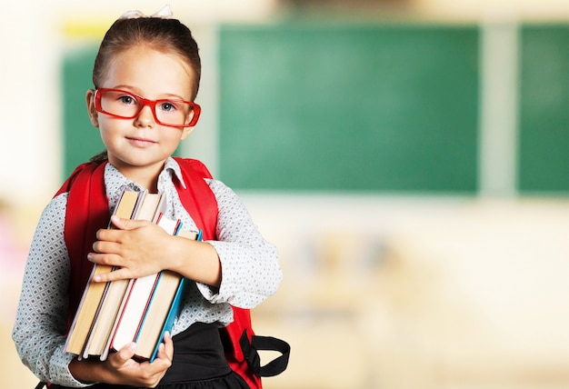 Porträt des jungen netten Mädchens mit Büchern