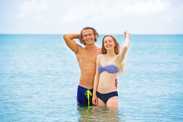 Porträt des jungen Paares, das am Strand verliebt ist und Zeit zusammen genießt. Junges Paar, das Spaß an einer sandigen Küste hat.