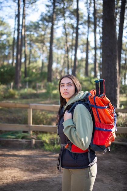 Porträt des jungen weiblichen Wanderers. Kaukasische Frau in Freizeitkleidung mit dunklem Haar und großem Rucksack. Hobby, Naturkonzept