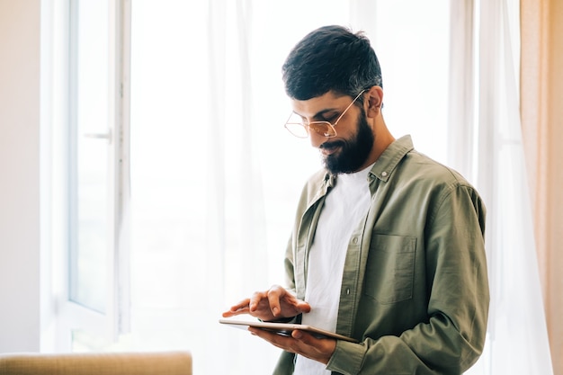 Porträt des kaukasischen Geschäftsmannes unter Verwendung des Tablet-Computers, online arbeitend.