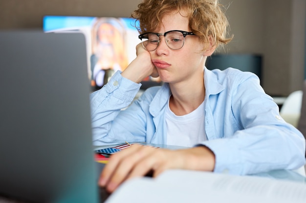 Porträt des kaukasischen Jungen, der zu Hause studiert