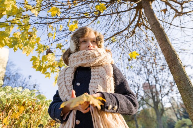 Porträt des Kindermädchens unter Ahornbaum, Hintergrundherbstsonnenpark