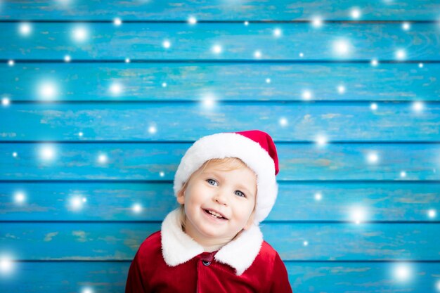 Porträt des Kindes, das Weihnachtsmann-Kostüm trägt. Kind, das Spaß zur Weihnachtszeit hat. Frohe Weihnachten-Konzept