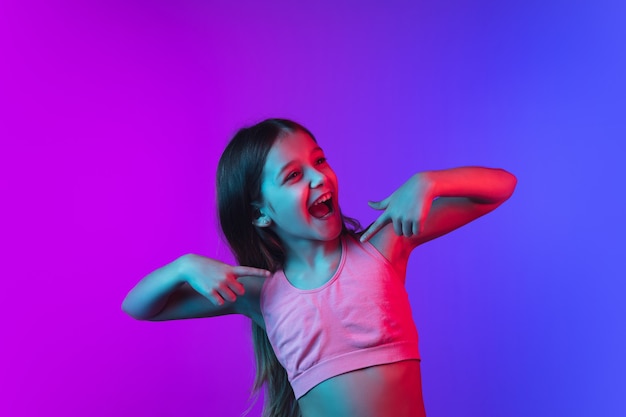 Porträt des kleinen Mädchens lokalisiert auf Neonhintergrund