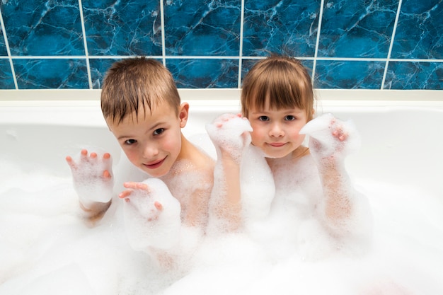 Porträt des kleinen Mädchens und des Jungen der hübschen Kinder im Bad. Hygienekonzept.