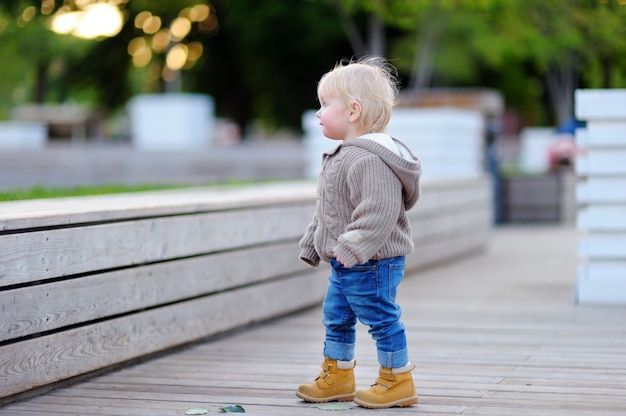 Porträt des Kleinkindjungen gehend in eine Großstadt