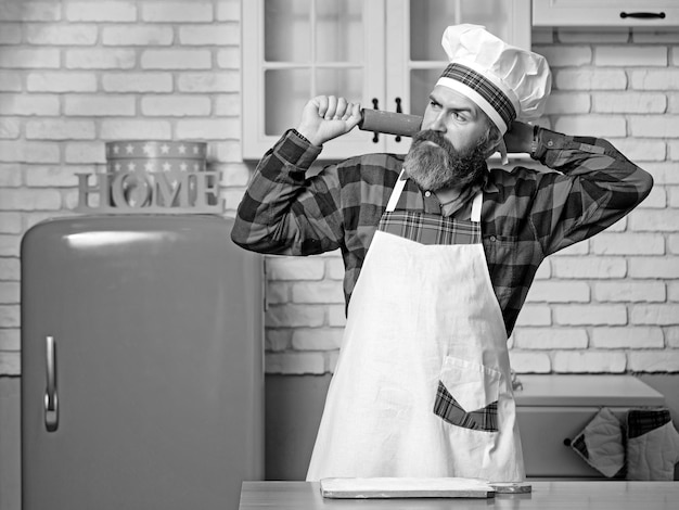 Porträt des Küchenchefs in Uniform in der heimischen Küche