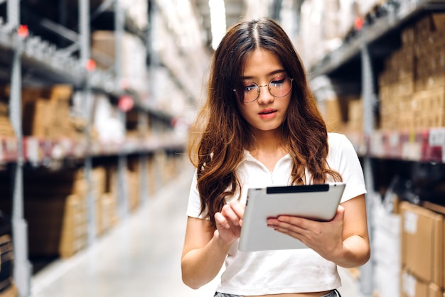 Porträt des lächelnden asiatischen Ingenieurs in den Helmbestellungsdetails der Frau auf dem Tablet-Computer