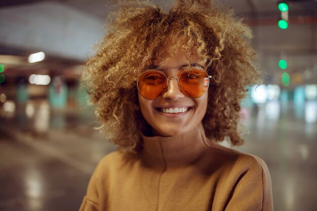 Porträt des lächelnden gemischten Rassen-Hip-Hop-Mädchens mit Sonnenbrille, die Kamera betrachtet.