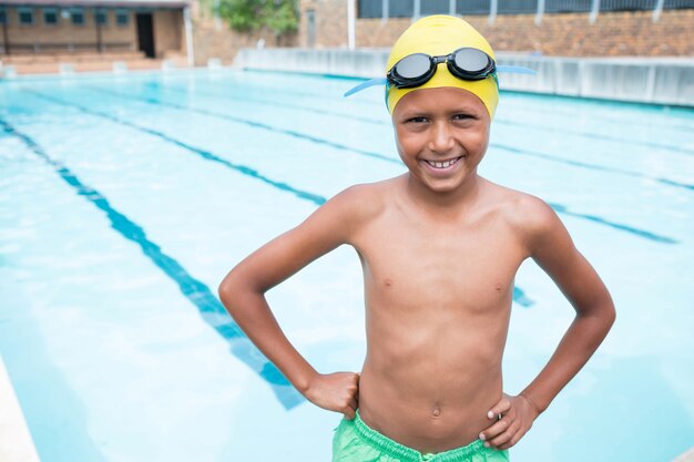 Porträt des lächelnden Jungen, der nahe Poolseite steht