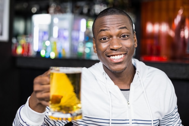 Porträt des lächelnden Mannes ein Bier trinkend