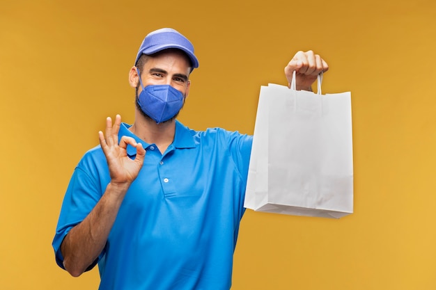 Porträt des Lieferboten, der Papierpaket hält