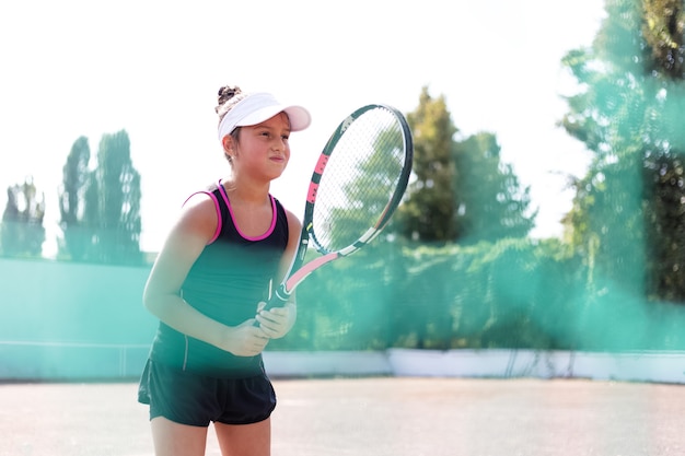 Porträt des Mädchens, das Tennis auf Sportplatz spielt