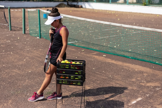 Porträt des Mädchens, das Tennis auf Sportplatz spielt