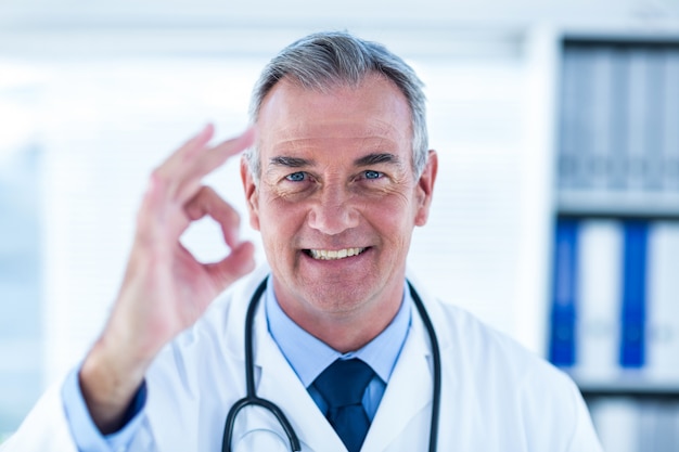 Porträt des männlichen Doktors ok zeigend unterzeichnen Sie herein Klinik