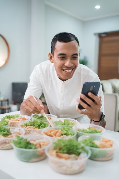 Porträt des männlichen Hausverpflegungsdienstes, der Lunchbox für Online-Bestellung zum Mitnehmen vorbereitet