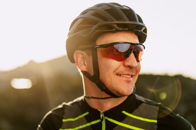 Porträt des männlichen kaukasischen Radfahrers mit Helm und Brille schließen oben