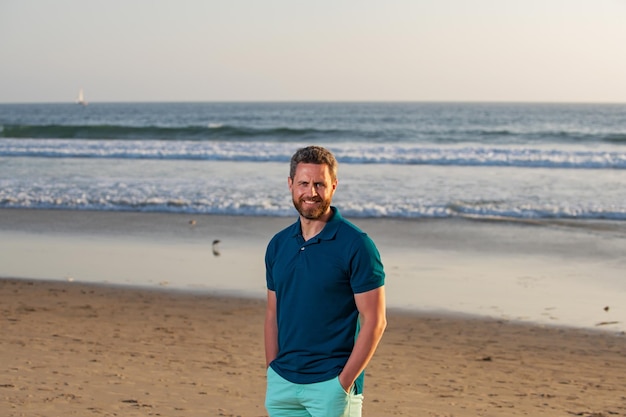 Porträt des Mannes am Strand. Glücklicher junger Mann im Freien an einem sonnigen Tag.