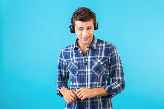 Porträt des mannes, der musik auf kabellosen kopfhörern hört, die spaß auf blau haben