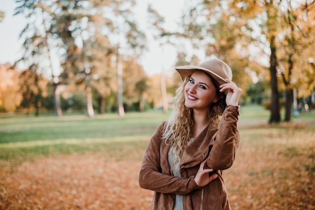 Porträt des Mode Bloggermädchens aufwerfend im Herbstpark.