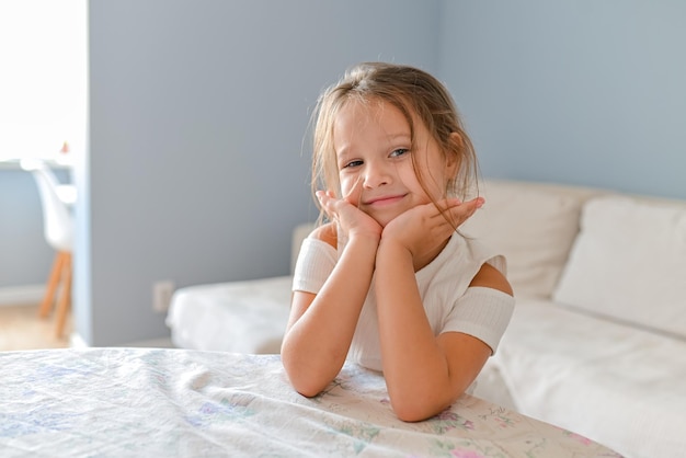 Porträt des netten europäischen kleinen Kleinkindmädchens über dem rosa Hintergrund, der Kamera betrachtet Kindermodell im weißen T-Shirt Werbung für Kinderprodukte