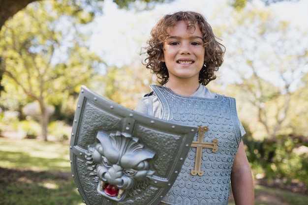 Porträt des netten Jungen vortäuschend, ein Ritter zu sein