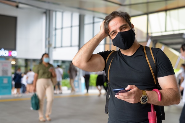 Porträt des persischen Touristenmannes mit Maske zum Schutz vor dem Ausbruch des Koronavirus im Einkaufszentrum in der Stadt