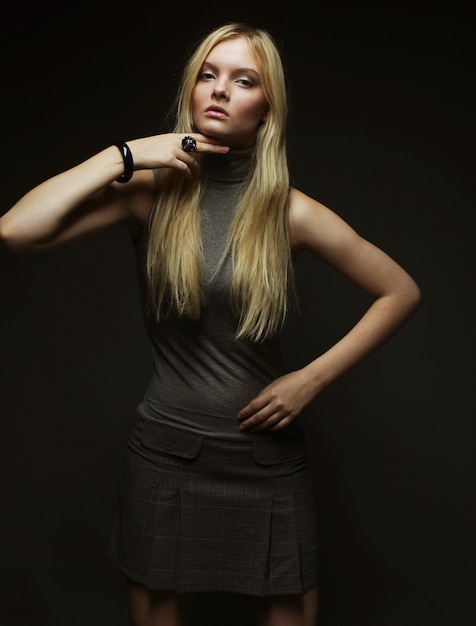 Porträt des schönen jungen blonden Mädchens über der Dunkelheit