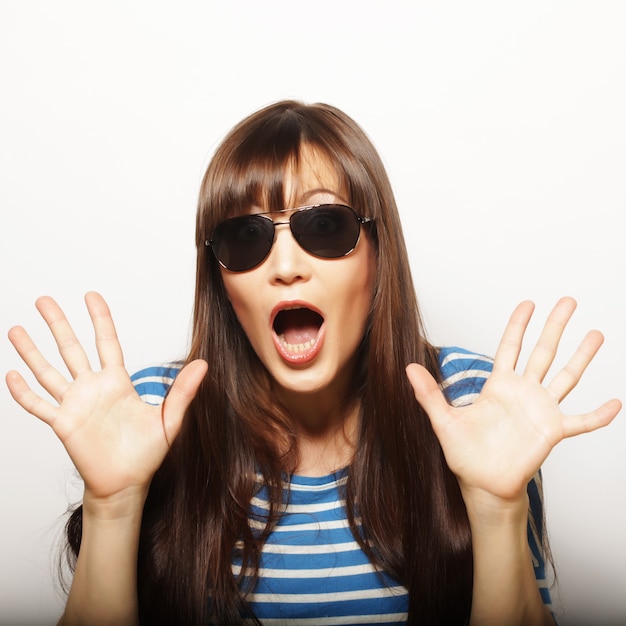 Porträt des schönen jungen Mädchens in der Sonnenbrille ein Blick der Überraschung