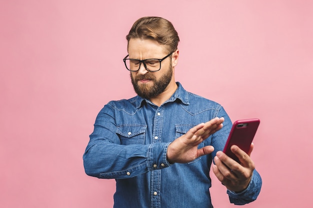 Porträt des schönen jungen Mannes mit Brille unter Verwendung des Telefons