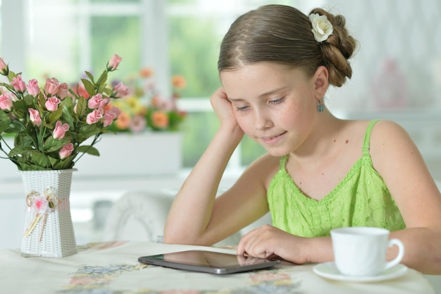 Porträt des schönen kleinen Mädchens mit Tabletten-PC