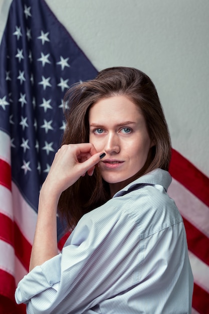 Porträt des schönen Mädchens im Hemd auf amerikanischem Flaggenhintergrund schließen oben
