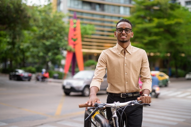 Porträt des schönen schwarzen jungen afrikanischen Geschäftsmannes, der Freizeitkleidung draußen in der Stadt trägt